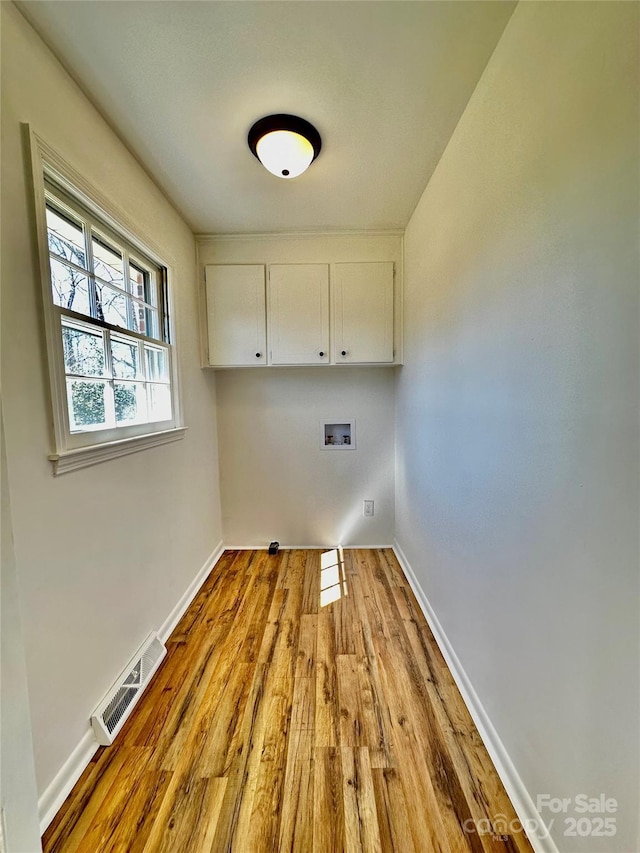 laundry room featuring washer hookup, wood finished floors, visible vents, baseboards, and cabinet space