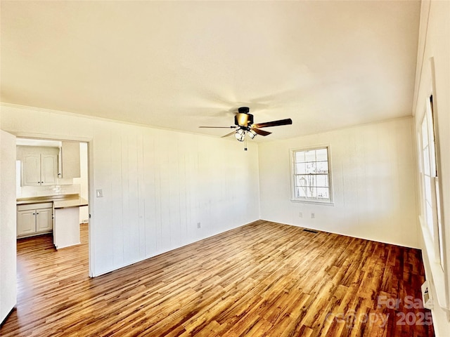 empty room with a ceiling fan and wood finished floors