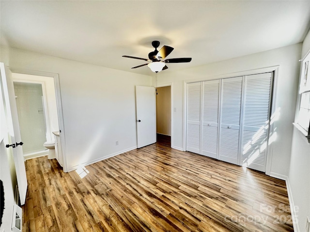 unfurnished bedroom with a closet, ceiling fan, baseboards, and wood finished floors