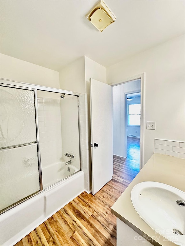 bathroom featuring shower / bath combination with glass door, wood finished floors, and vanity