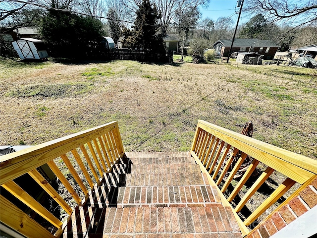 wooden deck with a storage unit and an outdoor structure