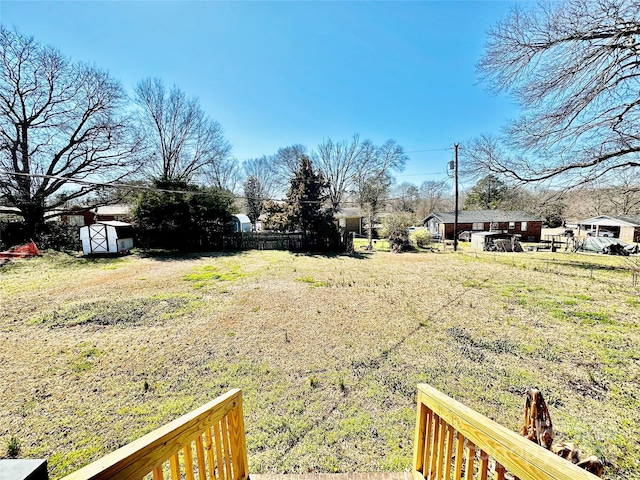 view of yard with an outdoor structure, fence, and a shed