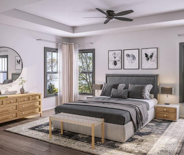 bedroom featuring a ceiling fan, baseboards, a tray ceiling, and wood finished floors