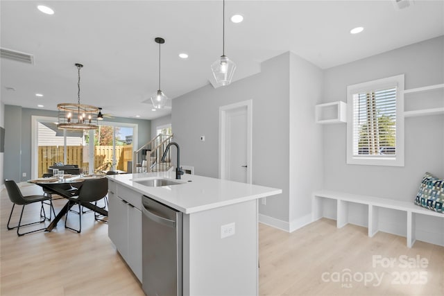 kitchen featuring visible vents, light countertops, light wood-type flooring, stainless steel dishwasher, and a sink