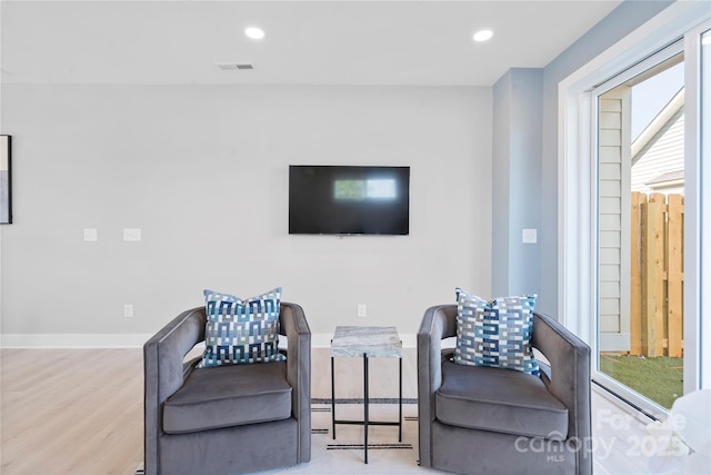 living room featuring recessed lighting, visible vents, baseboards, and wood finished floors