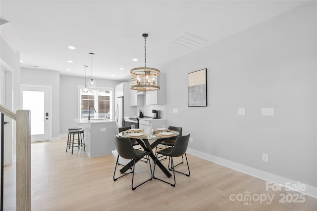 dining space featuring light wood finished floors, baseboards, and recessed lighting