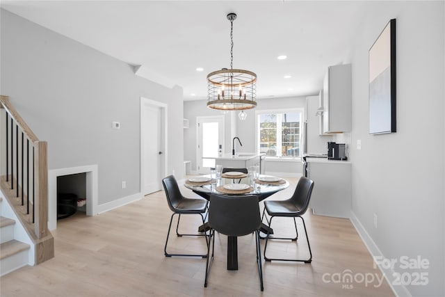 dining room featuring stairs, light wood finished floors, baseboards, and recessed lighting