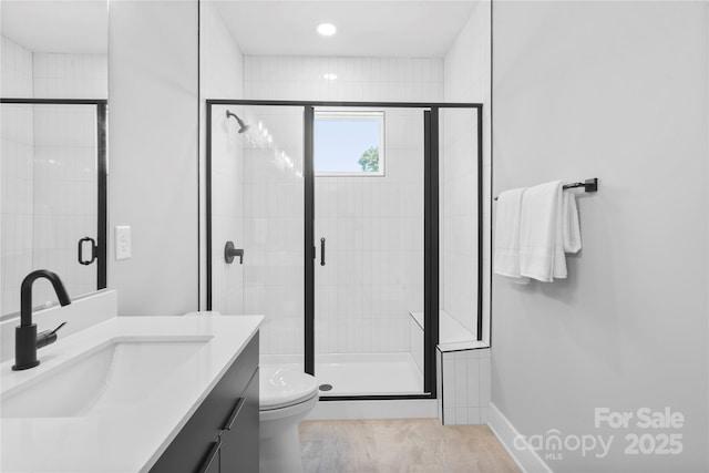 full bath featuring toilet, a shower stall, and vanity