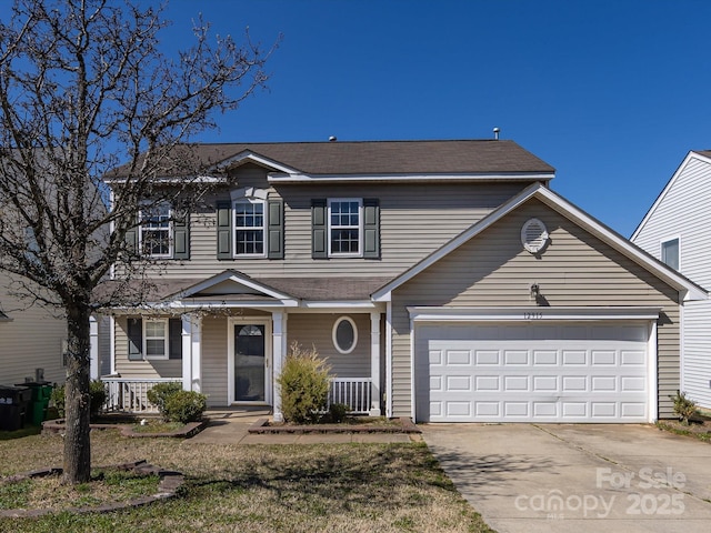 traditional home featuring covered porch, driveway, and an attached garage