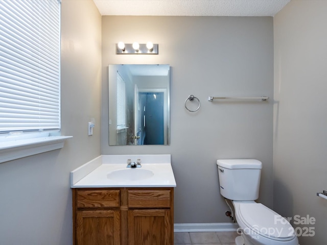 bathroom with baseboards, vanity, toilet, and tile patterned floors