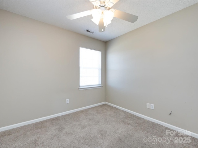carpeted spare room with visible vents, ceiling fan, a textured ceiling, and baseboards