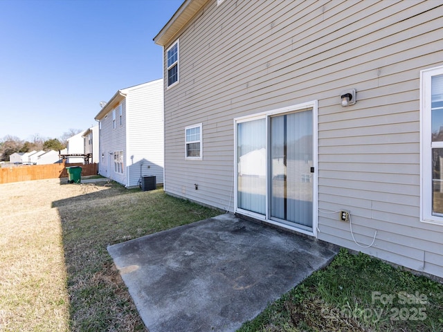 exterior space with central air condition unit, a patio area, a lawn, and fence