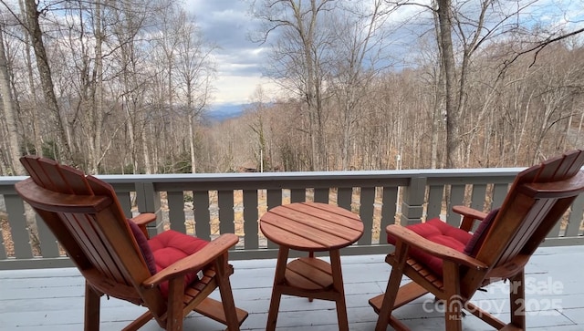 wooden deck featuring a forest view