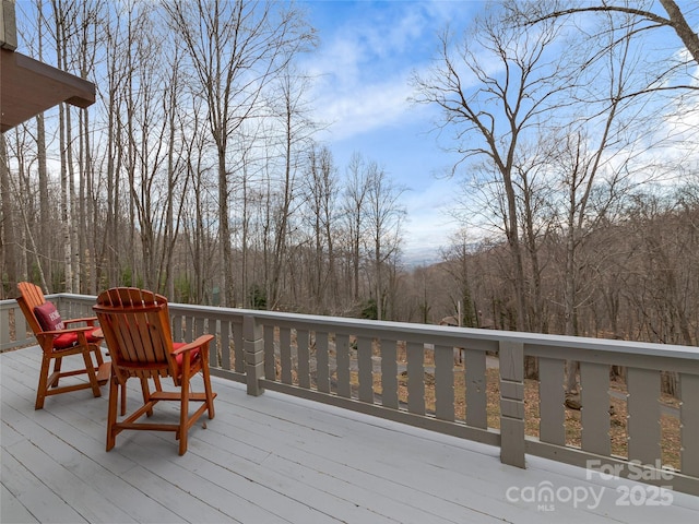 wooden terrace featuring a wooded view