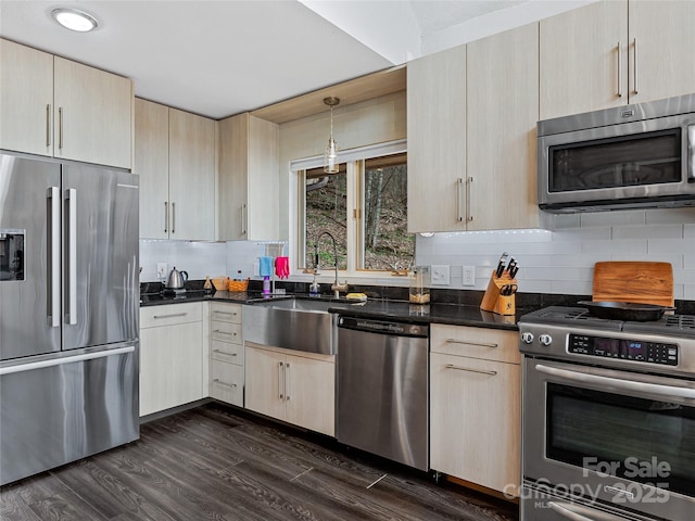 kitchen featuring tasteful backsplash, dark wood finished floors, stainless steel appliances, light brown cabinets, and a sink