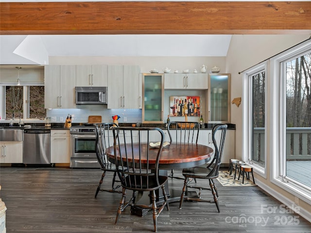 dining room with dark wood-style floors, vaulted ceiling, and baseboards