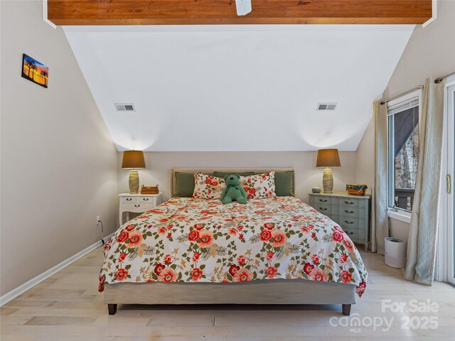 bedroom featuring lofted ceiling with beams, light wood finished floors, baseboards, and visible vents