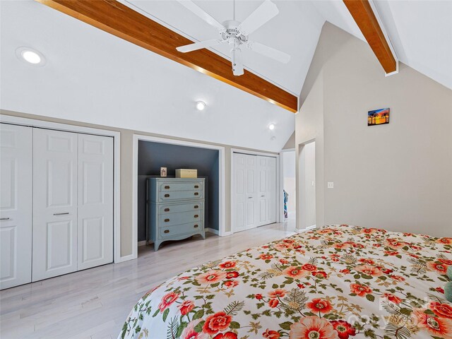 bedroom featuring ceiling fan, vaulted ceiling with beams, light wood-style floors, two closets, and recessed lighting