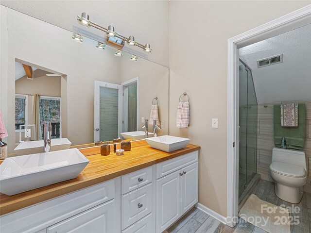 full bath with double vanity, a stall shower, visible vents, and a sink