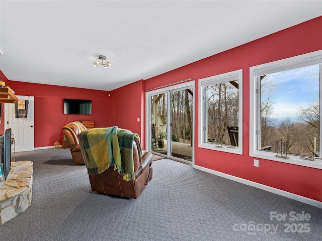 home theater room featuring a fireplace, carpet flooring, and baseboards