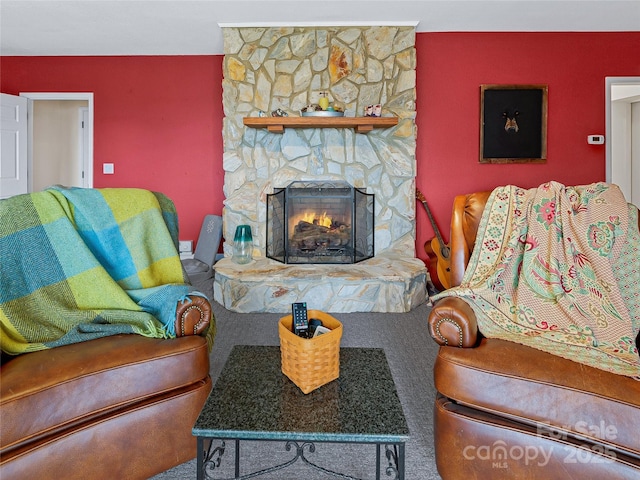 living room featuring carpet flooring and a stone fireplace