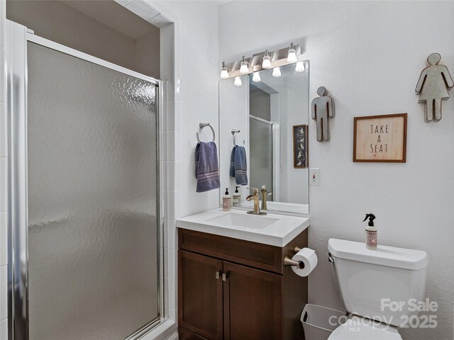 bathroom featuring a stall shower, vanity, and toilet