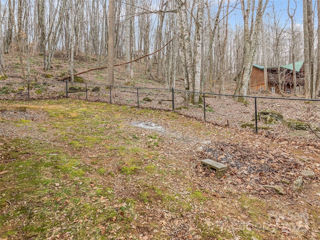 view of yard with fence and a view of trees