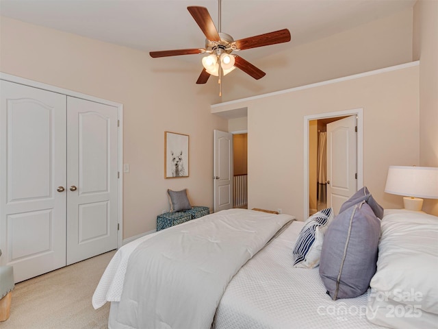 bedroom featuring light carpet, a ceiling fan, and a closet