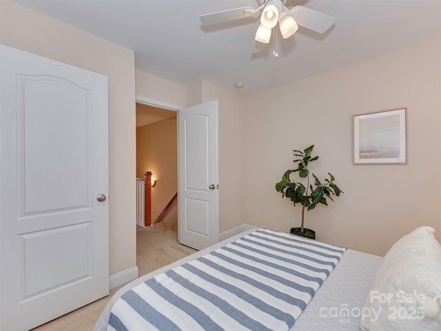 bedroom featuring light colored carpet, ceiling fan, and baseboards