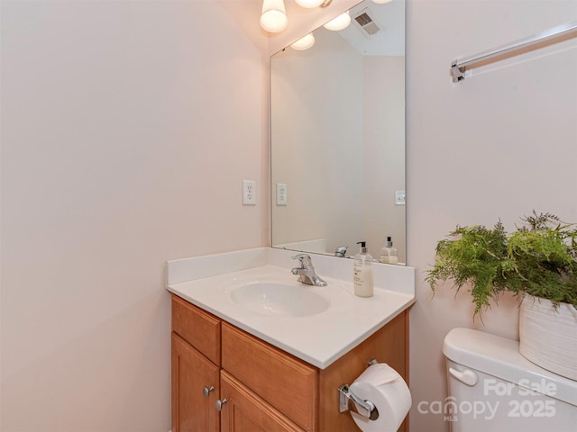 bathroom featuring toilet, visible vents, and vanity