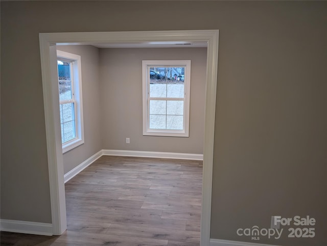 empty room with baseboards and wood finished floors