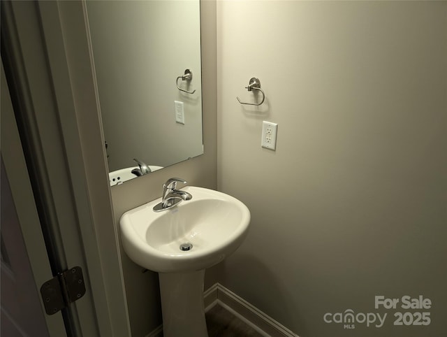 bathroom with a sink and baseboards