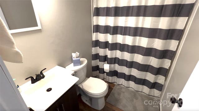 bathroom featuring curtained shower, vanity, and toilet