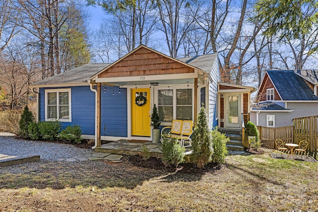 view of front of home with fence and a porch