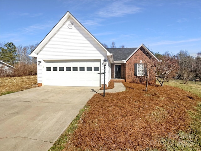 ranch-style home featuring a garage, concrete driveway, and brick siding