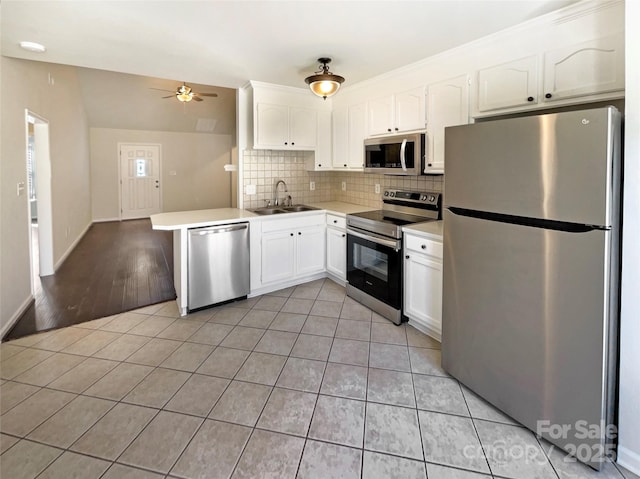 kitchen with white cabinets, light tile patterned floors, stainless steel appliances, and a sink