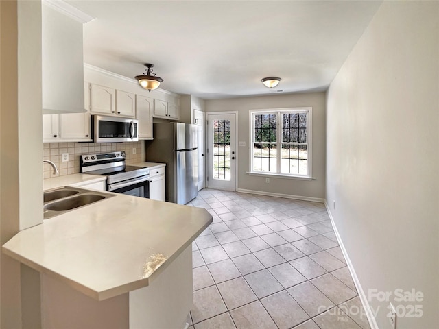 kitchen featuring light tile patterned floors, stainless steel appliances, light countertops, backsplash, and a sink