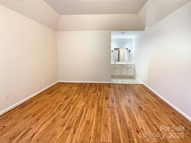 empty room featuring light wood finished floors and baseboards