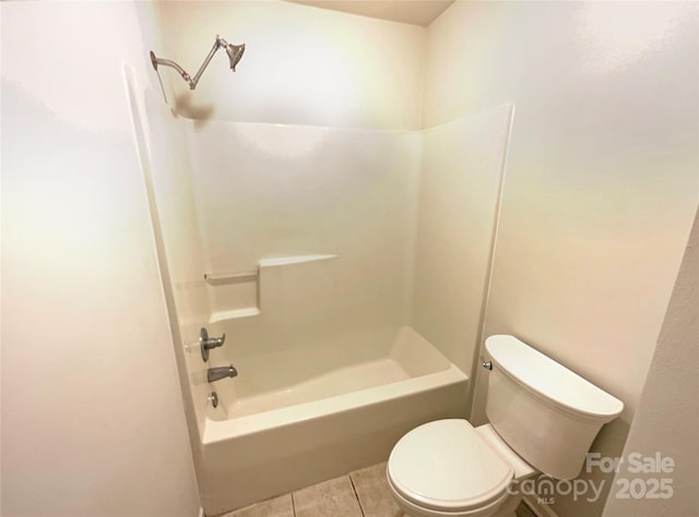 bathroom featuring toilet, tile patterned flooring, and washtub / shower combination