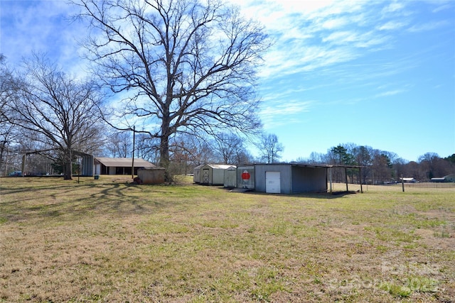 view of yard with a garage, an outbuilding, and an outdoor structure