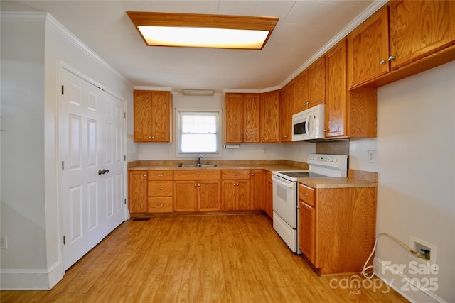 kitchen with white appliances, a sink, and brown cabinets