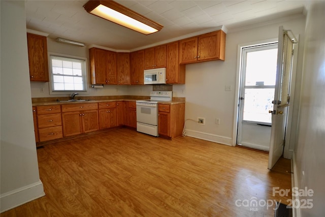 kitchen with white appliances, baseboards, light wood-style floors, light countertops, and brown cabinetry