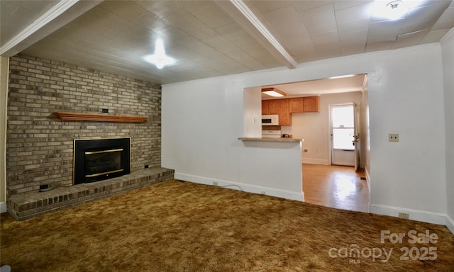 unfurnished living room featuring baseboards, a fireplace, carpet flooring, and crown molding