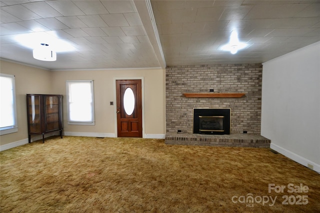 unfurnished living room featuring ornamental molding, carpet, a brick fireplace, and baseboards