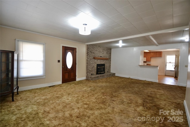 unfurnished living room with carpet, a fireplace, baseboards, and ornamental molding