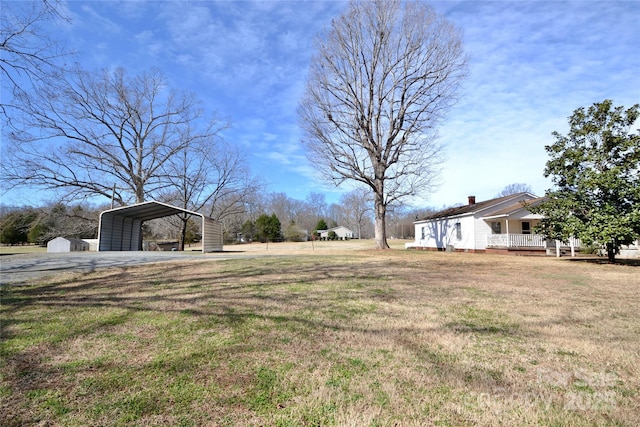 view of yard with covered porch and a detached carport