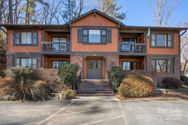 view of front facade with a balcony and brick siding