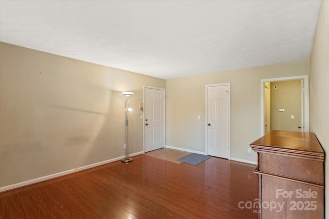 interior space featuring baseboards and wood finished floors