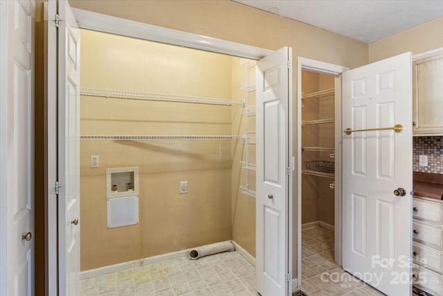 laundry area with a textured ceiling, hookup for a washing machine, laundry area, light floors, and electric dryer hookup