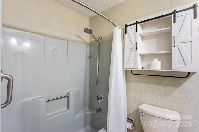 full bathroom with shower / tub combo, tile walls, toilet, and a textured ceiling